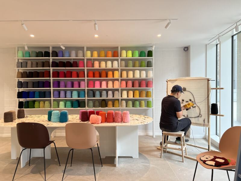 Founder Chun of Tufting London in the studio at a canvas, holding a tufting gun